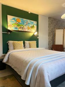 a bedroom with a large bed and a green wall at L'Etape du Bonheur in Cilaos