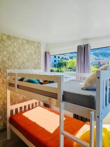 a bedroom with two bunk beds and a window at L'Etape du Bonheur in Cilaos