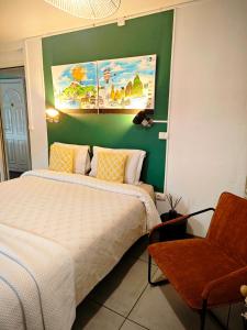 a bedroom with a white bed and a green wall at L'Etape du Bonheur in Cilaos