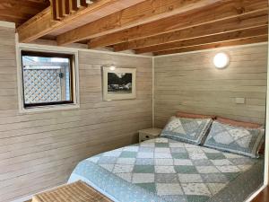 a small bedroom with a bed in a cabin at RIMU CABIN At the Bridge in Motungarara +6 photos