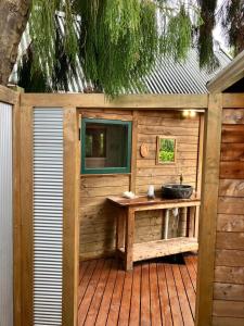 a wooden bathroom with a sink on a deck at RIMU CABIN At the Bridge in Motungarara +10 photos
