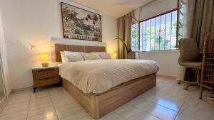 ein Schlafzimmer mit einem Bett, einem Fenster und einem Stuhl in der Unterkunft CASA BLANCA Port Royale - heated pool, ocean view, fibre net in Los Cristianos + 21 Fotos