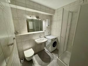une salle de bains avec lave-linge et lavabo dans l'établissement Apartment with underground parking in Langenfeld, à Langenfeld 1 autre photo