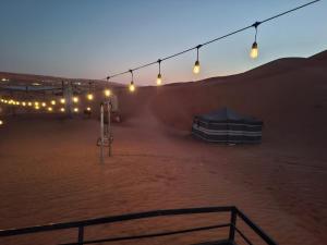 uma tenda no meio de um deserto com luzes em ESCAPE cAMp2 em Badīyah