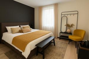 a bedroom with a bed and a mirror and a chair at Boutique Hotel Villa Elise in Winterswijk