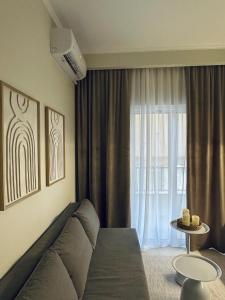 ein Wohnzimmer mit einer Couch und einem Fenster in der Unterkunft Symposio Apartments 3 in Preveza