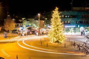 Chalet In The Countryside Kitchen Parking Lot في سبيز: شجرة عيد الميلاد في شارع المدينة في الليل