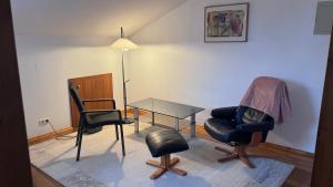 a living room with chairs and a table and a lamp at Ferienhaus in Lambsheim- "Familienfreundlich", PlayStation-FIFA in Lambsheim +35 photos