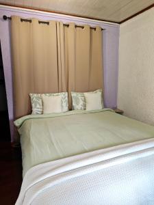 a large bed with white sheets and pillows at L'Etape du Bonheur in Cilaos