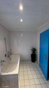 a bathroom with a tub and a potted plant at Ferienhaus in Lambsheim- "Familienfreundlich", PlayStation-FIFA in Lambsheim
