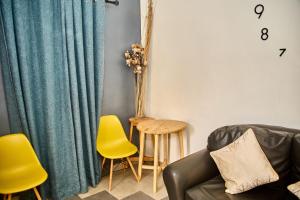 ParakouRésidences Fifamè的带沙发和黄色椅子的客厅