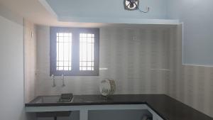 una cocina con fregadero y ventana en Urban white villa homestay, en Pondicherry 38 fotos más