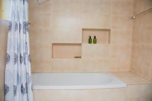 Zanube Apartments في ندولا: حمام مزود بحوض استحمام وزجاجتين +9 صور