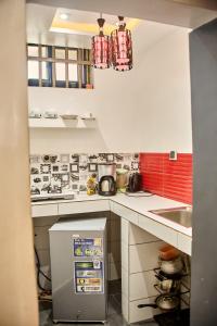 ParakouRésidences Fifamè的一个小厨房，白色台面，红色瓷砖。