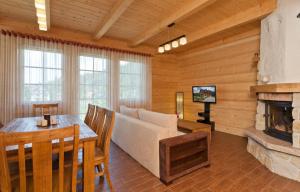 een woonkamer met een bank en een open haard bij Gorczański Domek - Koninki in Poręba Wielka