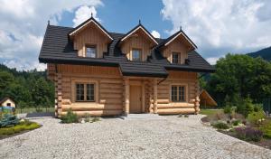 een blokhut met een zwart dak bij Gorczański Domek - Koninki in Poręba Wielka