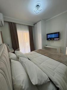 ein Schlafzimmer mit großem Bett und Flachbildfernseher in der Unterkunft Symposio Apartments 3 in Preveza