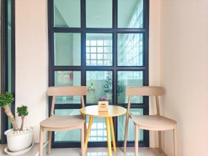 a table and two chairs in front of a window at Nan Minimal ที่พักน่านมินิมอล in Ban Na Tho