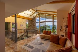 ein Wohnzimmer mit Couch und großem Fenster in der Unterkunft Villa Familiar 3BR Vistas al Valle & Naturaleza in Turrialba