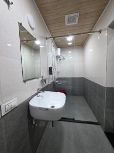 ein Badezimmer mit einem weißen Waschbecken und einem Spiegel in der Unterkunft Greenland Waterfront Kundapura in Kundapura + 83 Fotos