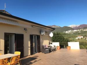 un patio con mesa, sillas y montañas en Amazing Terrace Colle Posta, 3 Bedr, Picinisco, 