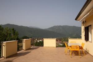 una mesa y sillas en un balcón con montañas en Amazing Terrace Colle Posta, 3 Bedr, Picinisco, 