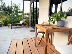 a patio with a wooden table and a bench at Entire Casita Ocean Breeze & Forest Calm in Troncones