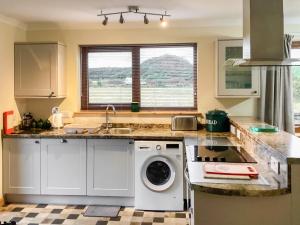 a kitchen with a washer and dryer on a counter at Mirodon in Brora
