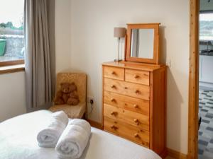 a bedroom with a bed and a dresser and a teddy bear at Mirodon in Brora +9 photos