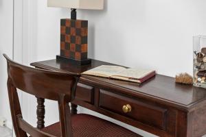 a desk with a lamp and a book on it at Selwyn Cottage in Burnt Pine