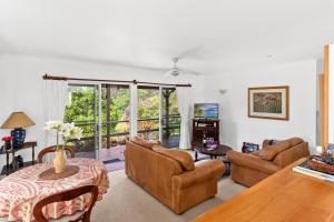 a living room with a couch and chairs and a table at Selwyn Cottage in Burnt Pine