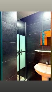 a bathroom with a glass shower and a sink at Hôtel Beauséjour in Marseille