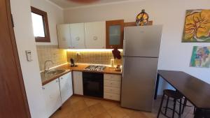 a kitchen with a refrigerator and a sink at La Dimora del Filosofo - Eraclito's Home in Olbia