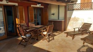 a wooden table and chairs on a patio at La Dimora del Filosofo - Eraclito's Home in Olbia