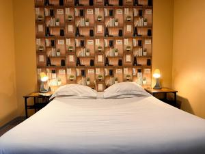 a bedroom with a bed with two lamps on two tables at Hôtel Beauséjour in Marseille