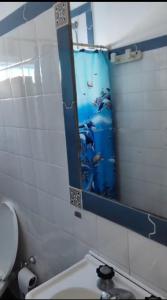 un bagno con uno specchio, un lavandino e un water di Duplex Gesell a Villa Gesell