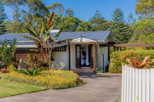 a house with a porch and a driveway at Selwyn Cottage in Burnt Pine