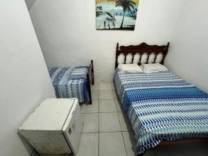 Una habitación con dos camas y una mesa dentro. en Pousada Jirê, en Itacaré