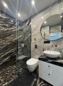 a bathroom with a toilet and a sink and a shower at Koralas in Klaipėda +7 photos