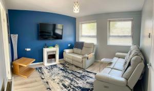 a living room with a couch and chairs and a tv at St Columb's Cottage in Derry Londonderry