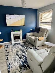 a living room with a couch and a fireplace at St Columb's Cottage in Derry Londonderry +2 photos