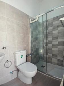 a bathroom with a toilet and a glass shower at The Blue Haven in Sal Rei