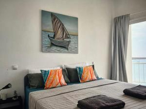 a bedroom with a bed with a sailboat painting on the wall at The Blue Haven in Sal Rei