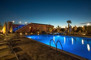 a pool at night with chairs and umbrellas at Badiula in Carlentini
