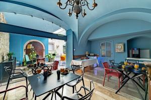 a dining room with blue walls and tables and chairs at Giselle Buda Castle in Budapest