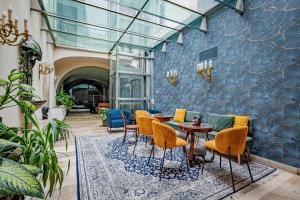 a lobby with chairs and tables and a blue wall at Giselle Buda Castle in Budapest