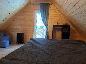 a bedroom with a bed and a large window at Juraszówka in Kamesznica