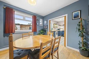 uma sala de jantar com uma mesa de madeira e uma cozinha em Beinn View 3 Bedroom House - Sea View - Ardersier em Ardersier