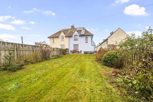 uma casa branca no meio de um quintal em Beinn View 3 Bedroom House - Sea View - Ardersier em Ardersier