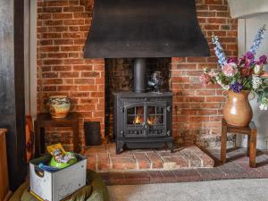 sala de estar con chimenea de ladrillo y fogones en The Old Thatch, en Hailsham